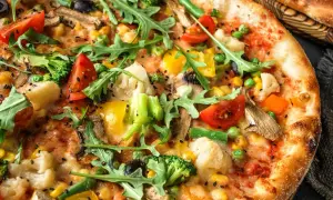 Pizza wegetariańska jakie dodatki? Brokuły, pomidorki, kukurydza, papryka, oliwki, pieczarki i rukola tworzą barwną kompozycję.