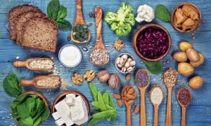 Różnorodne produkty roślinne bogate w białko: pieczywo, warzywa, nasiona, orzechy, tofu, fasola.