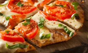 Pyszna pizza margherita z pomidorami i mozzarellą, idealna na bezglutenowy przepis.