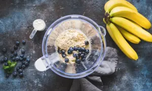 Jak zrobić shake proteinowy: banany, borówki, odżywka białkowa i mleko w blenderze.