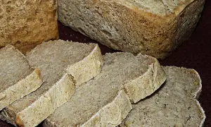 Chleb ryżowy bezglutenowy przepis. Pokrojone kromki domowego chleba ryżowego bezglutenowego na ciemnym tle.