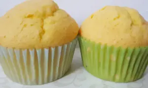 Dwa puszyste babeczki bezglutenowe w papierowych foremkach. Idealne na podwieczorek, gdy szukasz przepisu na babeczki bezglutenowe.