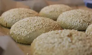 Świeżo upieczone bułki do burgerów bezglutenowe przepis. Posypane sezamem, gotowe do podania.