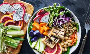 Kolorowa miska pełna zdrowia: grillowane tofu, komosa ryżowa, warzywa i owoce. To właśnie wegańskie co to znaczy – pyszne i odżywcze!