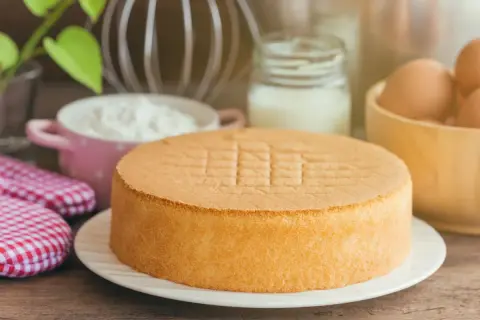 Idealny tort bezglutenowy przepis. Puszysty biszkopt, jajka, mleko i mąka czekają na przygotowanie.