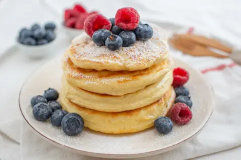 Puszyste pancakes z jagodami i malinami, idealne na zdrowe śniadanie. Ten przepis na zdrowe pancakes zachwyci każdego!
