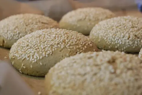 Świeżo upieczone bułki do burgerów bezglutenowe przepis. Posypane sezamem, gotowe do podania.