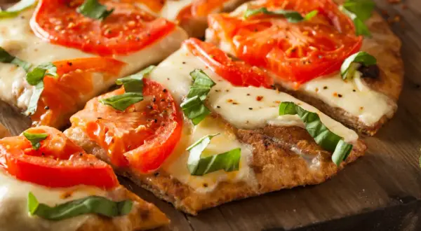 Pyszna pizza margherita z pomidorami i mozzarellą, idealna na bezglutenowy przepis.