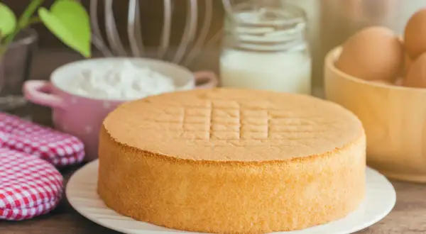 Idealny tort bezglutenowy przepis. Puszysty biszkopt, jajka, mleko i mąka czekają na przygotowanie.