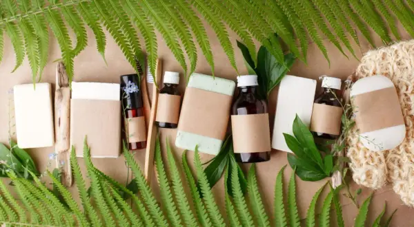 Naturalne produkty wegańskie: mydła, bambusowe szczoteczki, olejki w buteleczkach i gąbka.
