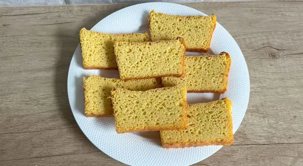 Chleb bezglutenowy z mąki kukurydzianej, pokrojony w kromki, ułożony na białym talerzu. Pyszny przepis!