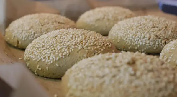 Świeżo upieczone bułki do burgerów bezglutenowe przepis. Posypane sezamem, gotowe do podania.