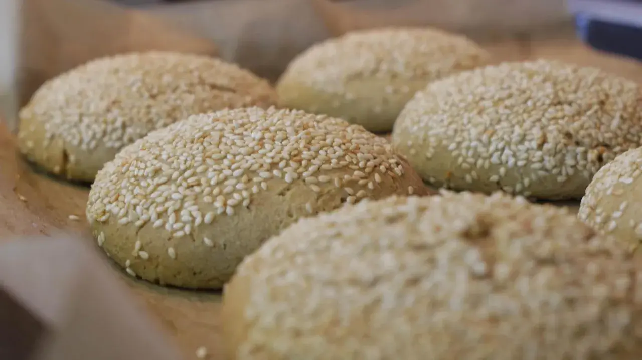 Świeżo upieczone bułki do burgerów bezglutenowe przepis. Posypane sezamem, gotowe do podania.