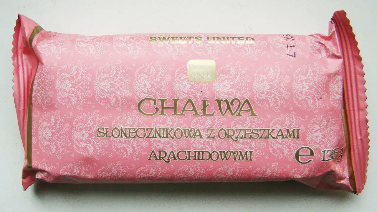 Różowa chałwa słonecznikowa z orzeszkami arachidowymi. Czy chałwa jest wegańska? Opakowanie z napisem