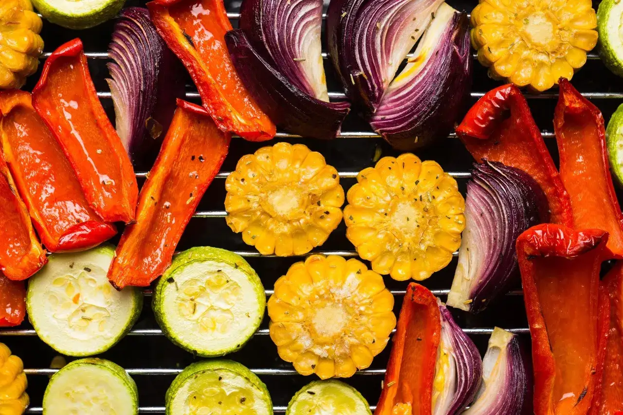 Kolorowe warzywa na grillu: papryka, cukinia, cebula i kukurydza. Idealne co na grilla wegetariańskie.