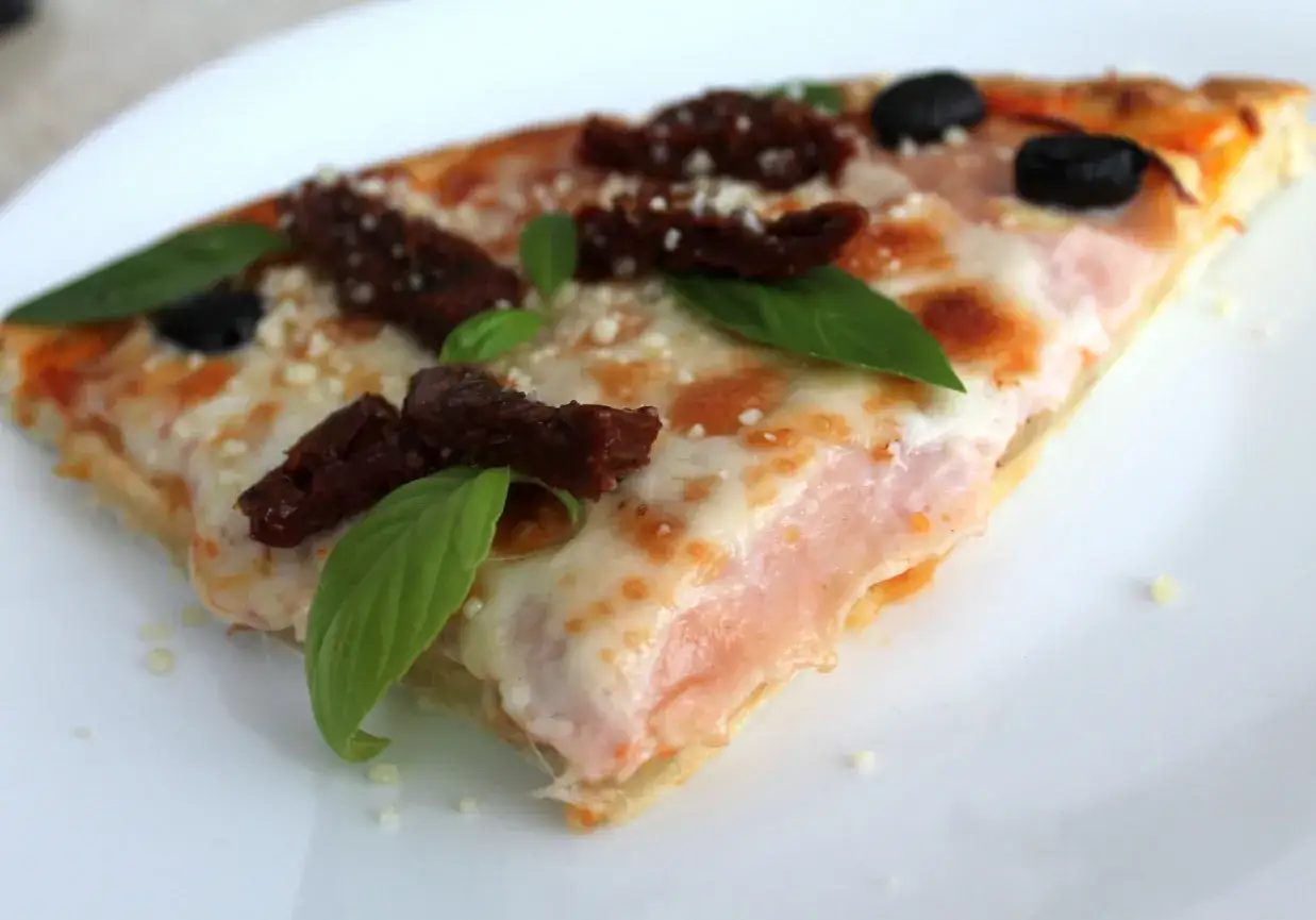 Pyszna pizza bezglutenowa z suszonymi pomidorami, oliwkami i bazylią. Idealna na szybki obiad, wypróbuj ten przepis!