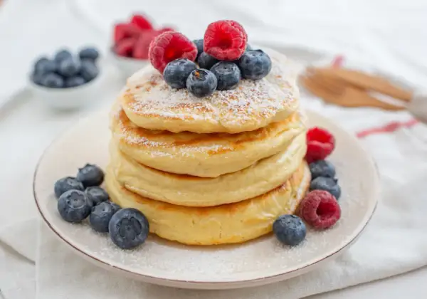 Puszyste pancakes z jagodami i malinami, idealne na zdrowe śniadanie. Ten przepis na zdrowe pancakes zachwyci każdego!