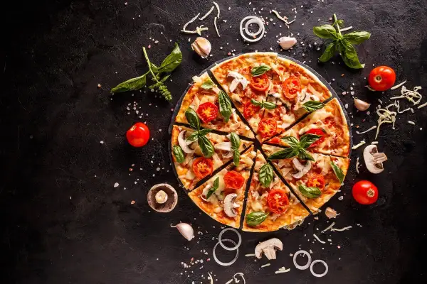 Pyszna pizza wegetariańska z pomidorami i bazylią. Zastanawiasz się, ile kalorii ma pizza wegetariańska?