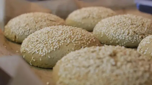Świeżo upieczone bułki do burgerów bezglutenowe przepis. Posypane sezamem, gotowe do podania.